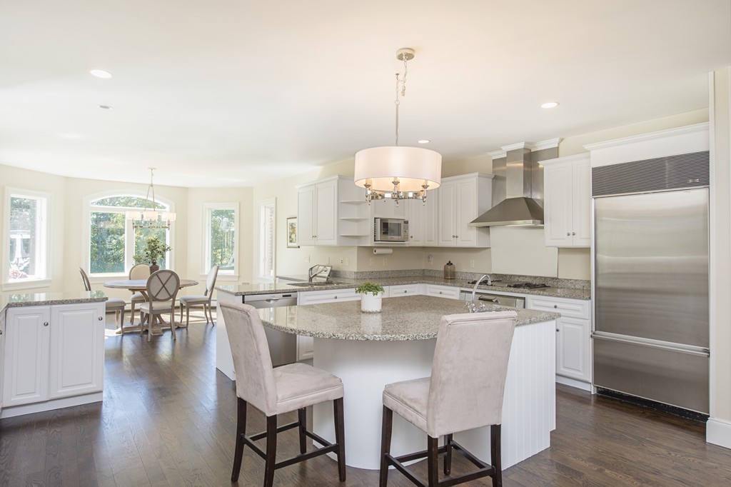 70 Black Oak Road Weston, MA 02493 - Photo 4 of 23 a kitchen with stainless steel appliances granite countertop a stove a sink a refrigerator a dining table and chairs with wooden floor