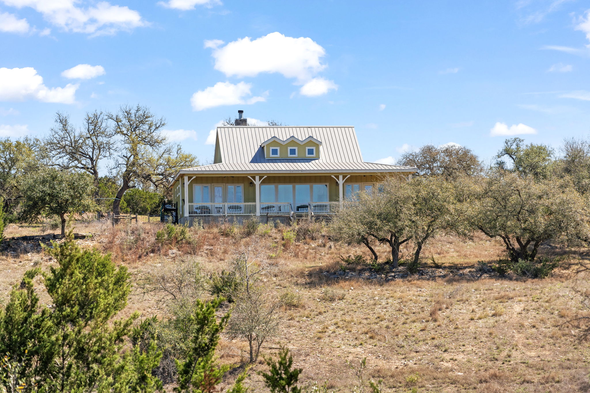 6350 Mt Sharp Road, Unit B Wimberley, TX 78676 - Photo 18 of 34 a view of a brick house with a yard and large trees