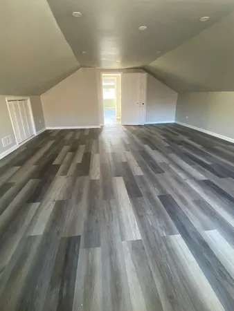 a view of empty room with wooden floor