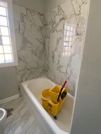 a bath tub sitting in a bathroom next to a window