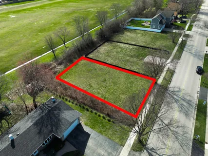 a view of a tennis ground with large trees