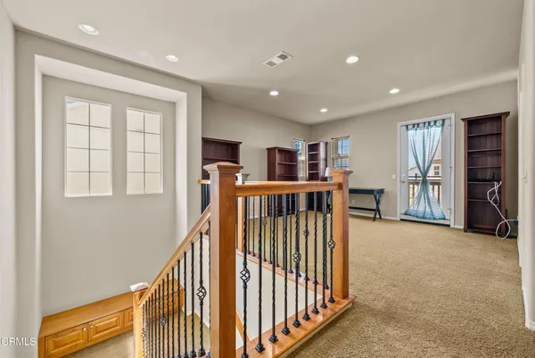 a view of a hallway with workspace and stairs