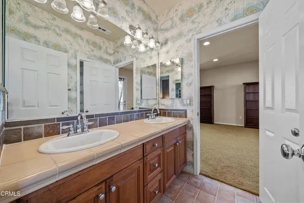 a bathroom with a granite countertop sink a large mirror and a shower
