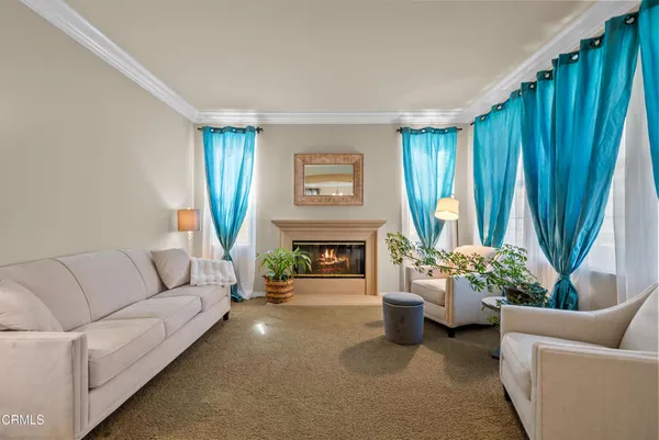 a living room with furniture a fireplace and a large window