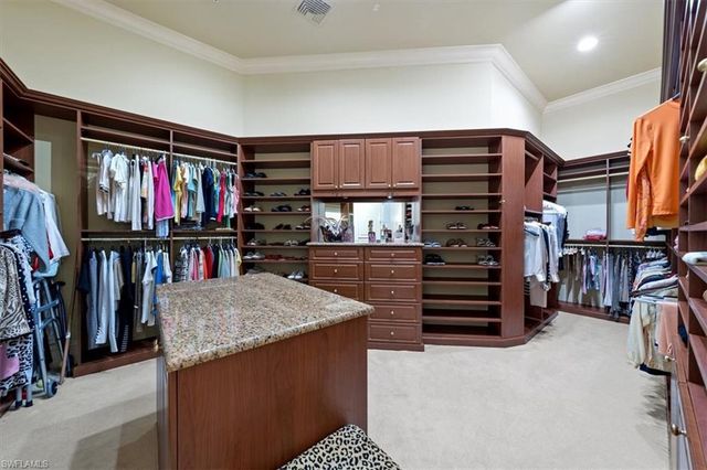a view of walk in closet with clothes and shoes