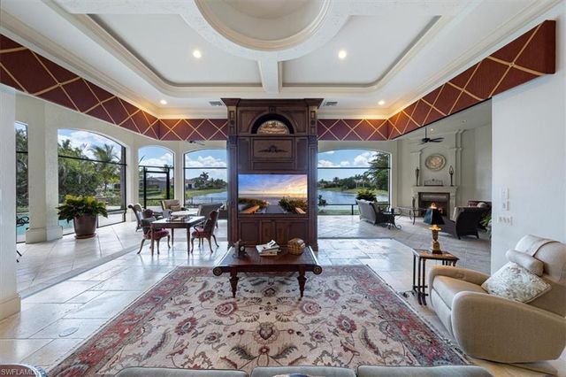 a living room with furniture a fireplace and a dining table with wooden floor