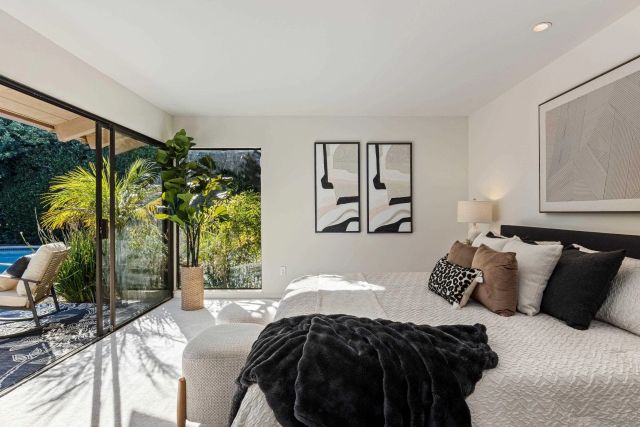a spacious bedroom with a bed a couch and potted plant