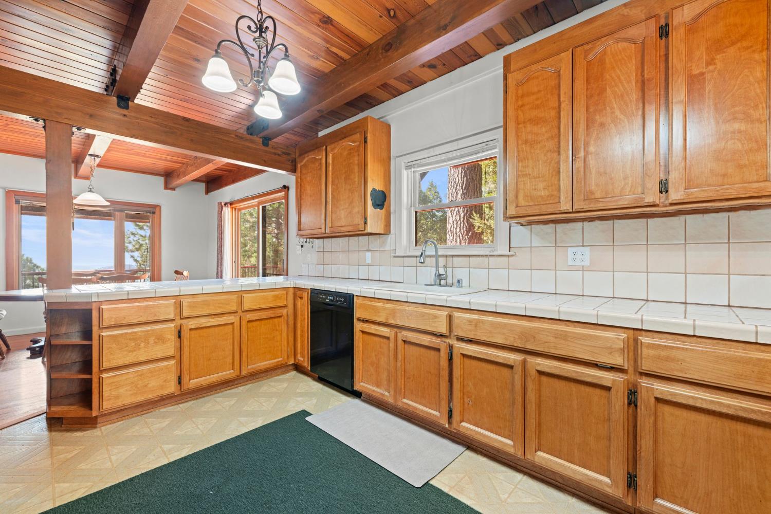 8061 Happy Valley Road Somerset, CA 95684 - Photo 11 of 66 a large kitchen with kitchen island granite countertop lots of wooden cabinets stainless steel appliances a large window and a sink