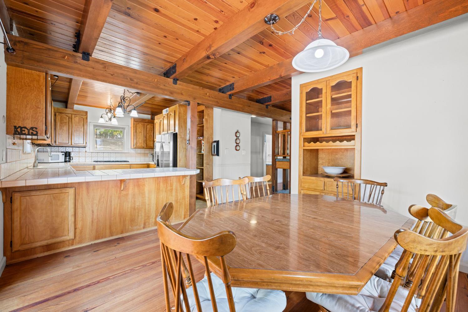8061 Happy Valley Road Somerset, CA 95684 - Photo 17 of 66 a dining hall with stainless steel appliances wooden floors a dining table and chairs with wooden floor