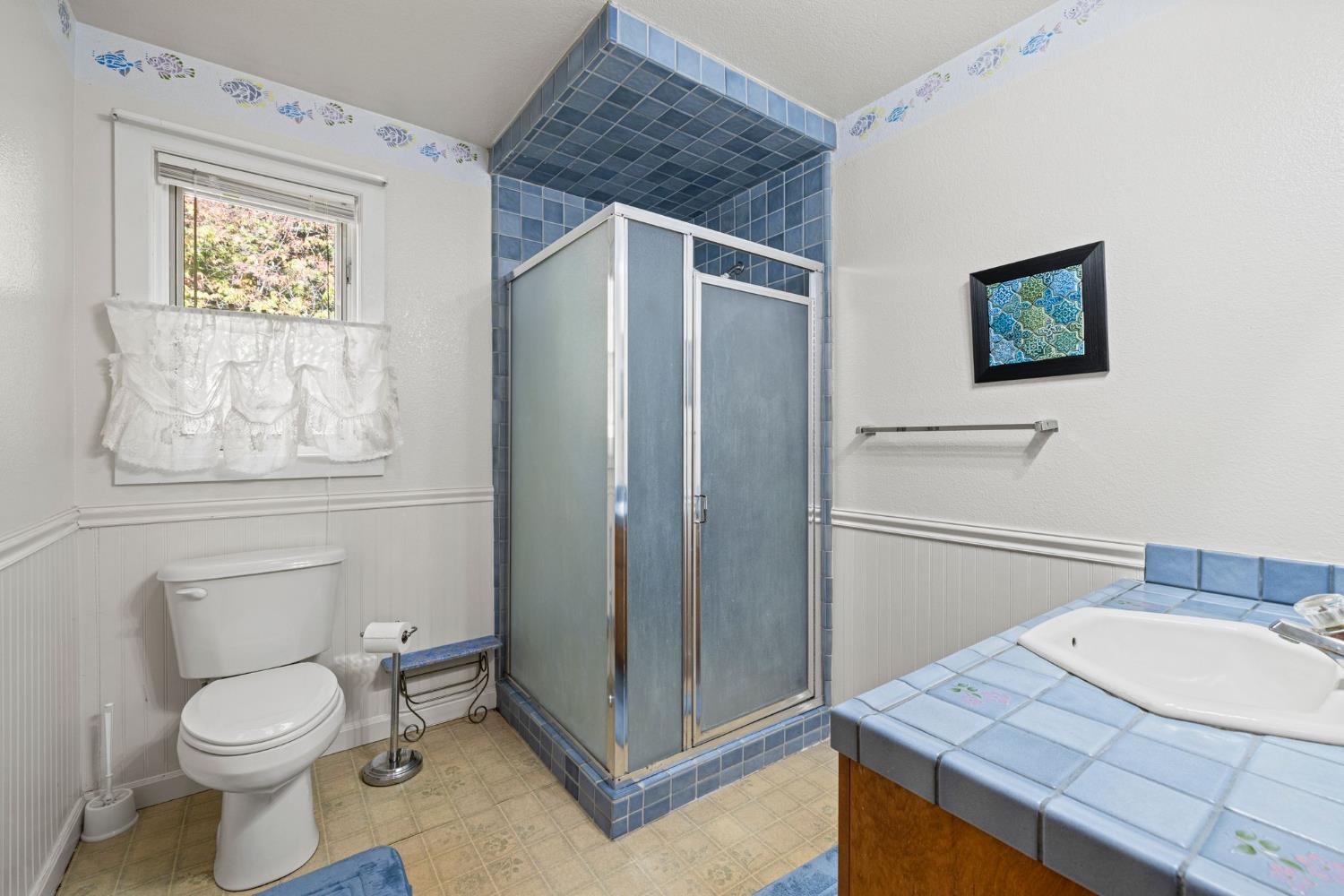 8061 Happy Valley Road Somerset, CA 95684 - Photo 26 of 66 a bathroom with a toilet a sink and mirror