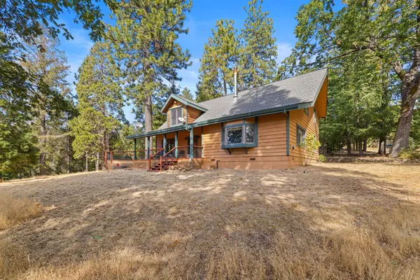 a large kitchen with kitchen island granite countertop lots of wooden cabinets stainless steel appliances a large window and a sink