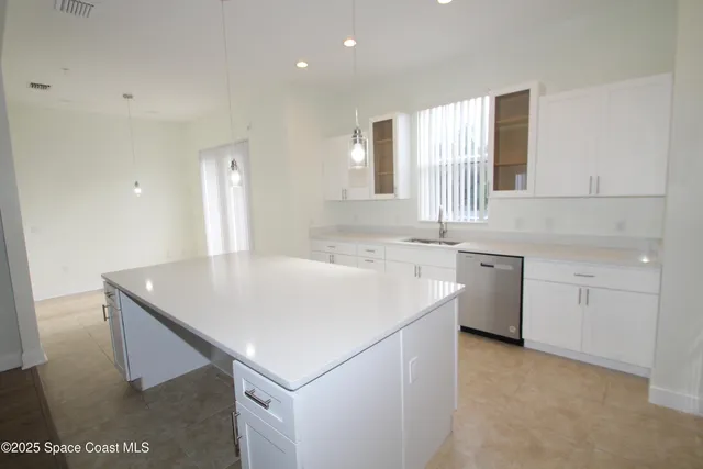 a kitchen with a sink a stove a refrigerator and white cabinets