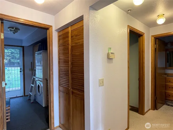 a view of a hallway with closet and a livingroom view
