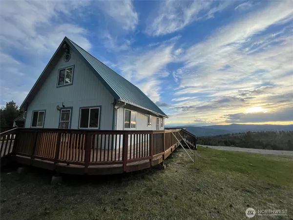 a view of a house with a yard and deck