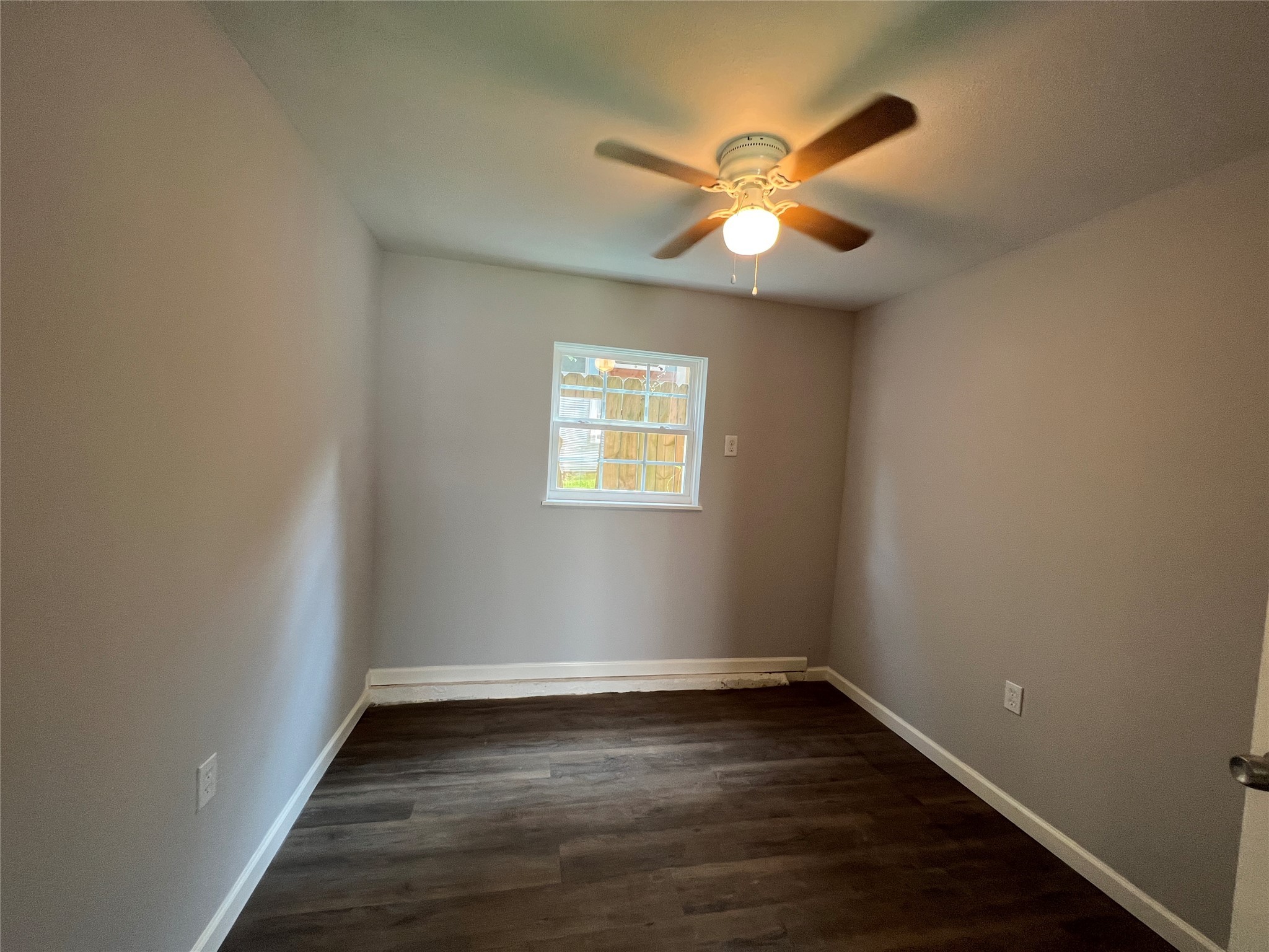 6823 Ave East Houston, TX 77011 - Photo 11 of 16 an empty room with wooden floor fan and windows
