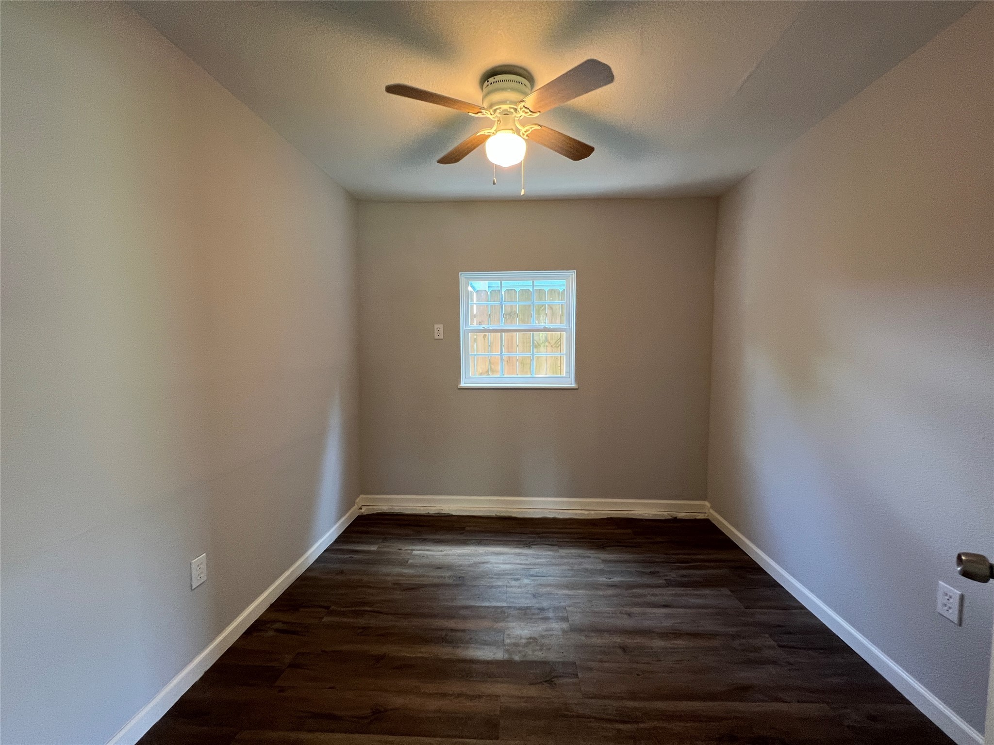 6823 Ave East Houston, TX 77011 - Photo 12 of 16 a view of an empty room with wooden floor and a ceiling fan