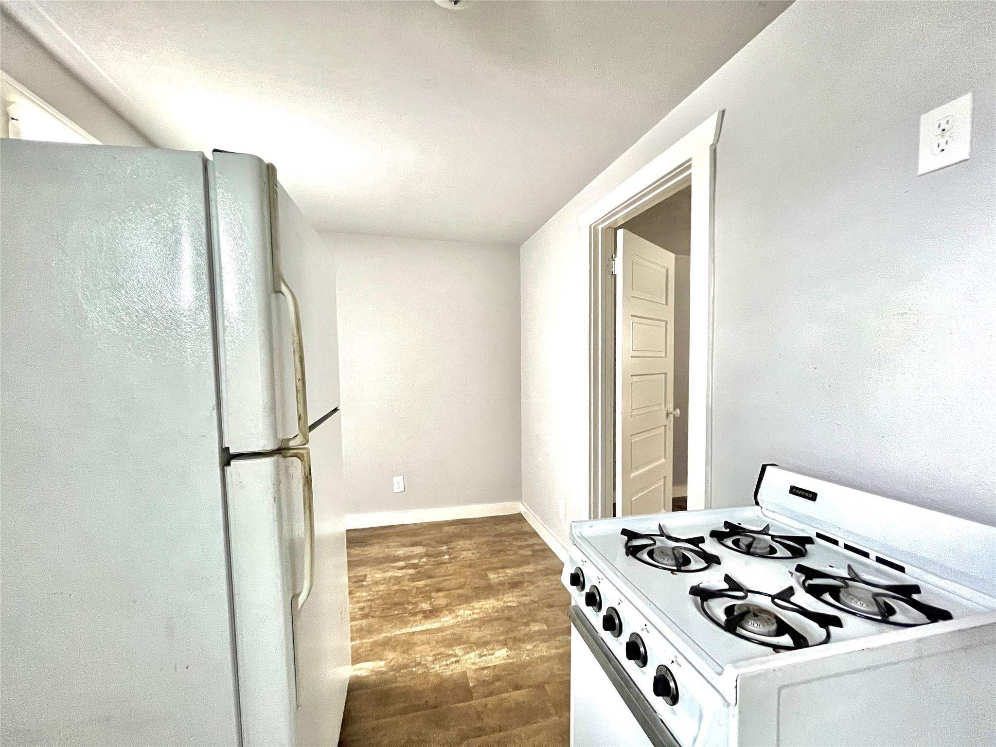 6823 Ave East Houston, TX 77011 - Photo 7 of 16 a white kitchen with a stove and a refrigerator