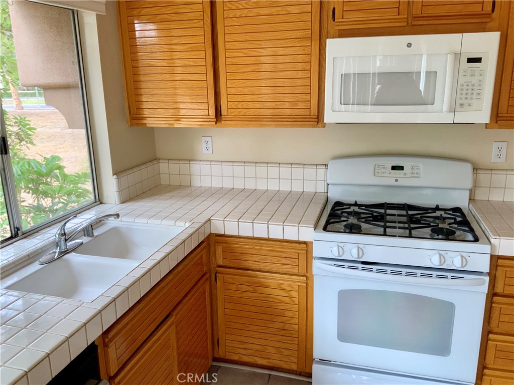 124 Cartier Aisle Irvine, CA 92620 - Photo 12 of 31 a kitchen with windows and a sink