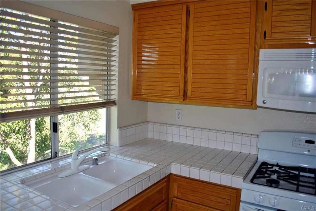 124 Cartier Aisle Irvine, CA 92620 - Photo 14 of 31 a kitchen with granite countertop a sink and a window