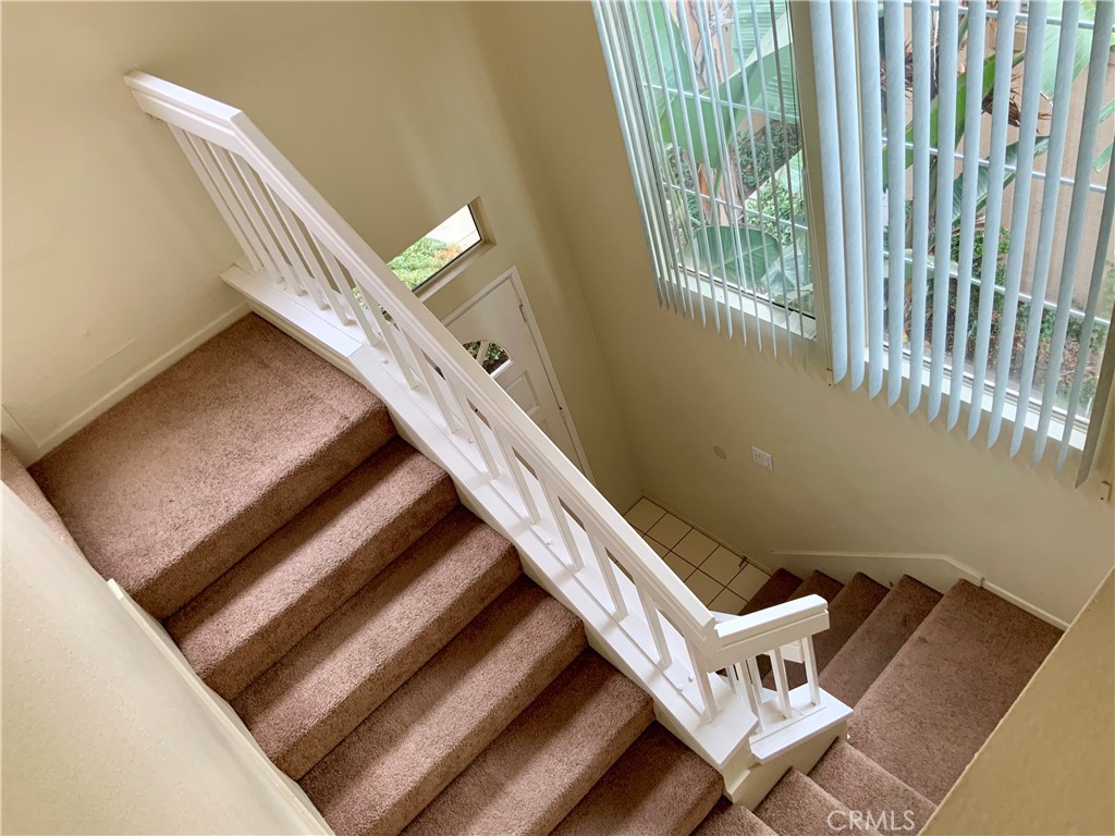 124 Cartier Aisle Irvine, CA 92620 - Photo 3 of 31 a view of an empty room with wooden floor and stairs