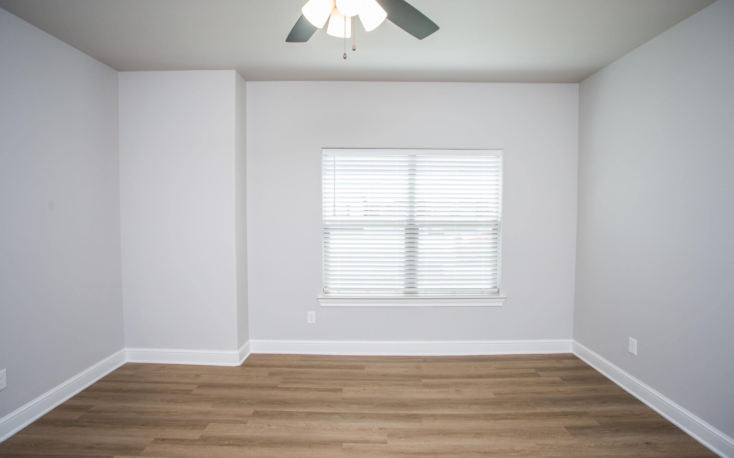 2544 137th Street Lubbock, TX 79423 - Photo 19 of 43 an empty room with wooden floor and windows