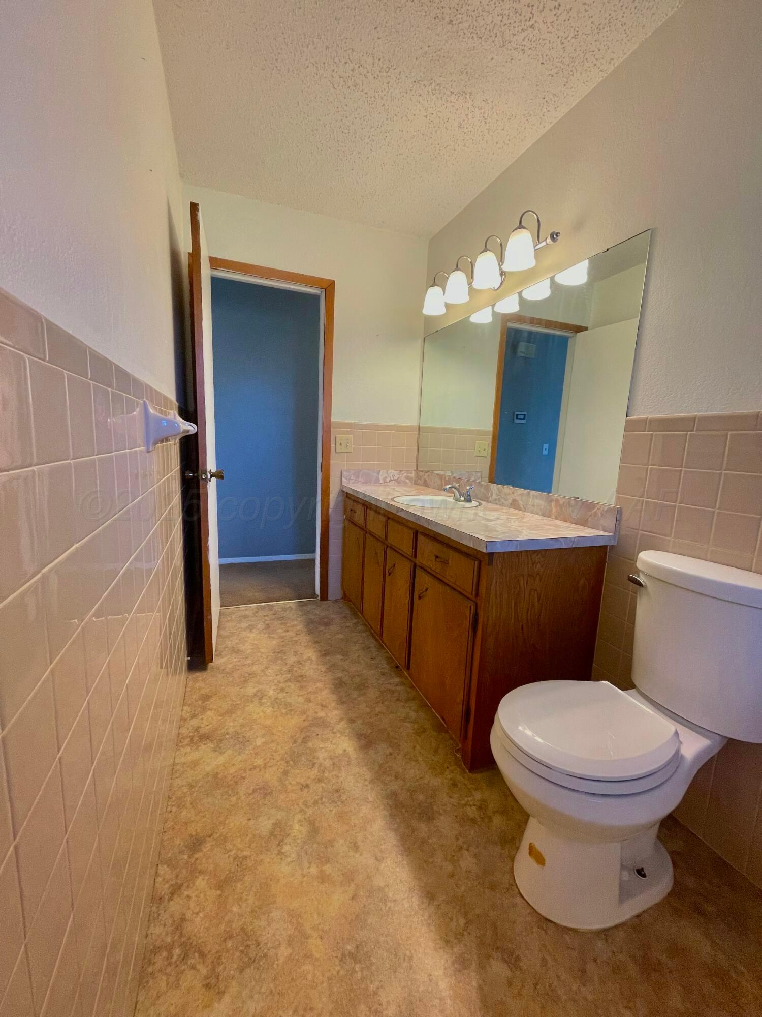 708 North Arizona Street Shamrock, TX 79079 - Photo 7 of 12 a bathroom with a toilet a sink and mirror