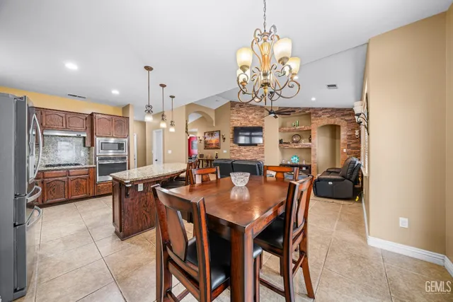 a dining room filled chandelier and wooden furniture