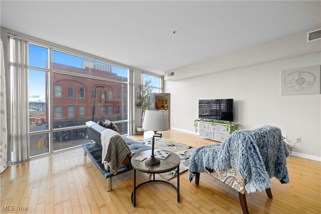 2222 Detroit Avenue, Unit 519 Cleveland, OH 44113 - Photo 12 of 30 Living room with floor to ceiling windows and hardwood flooring