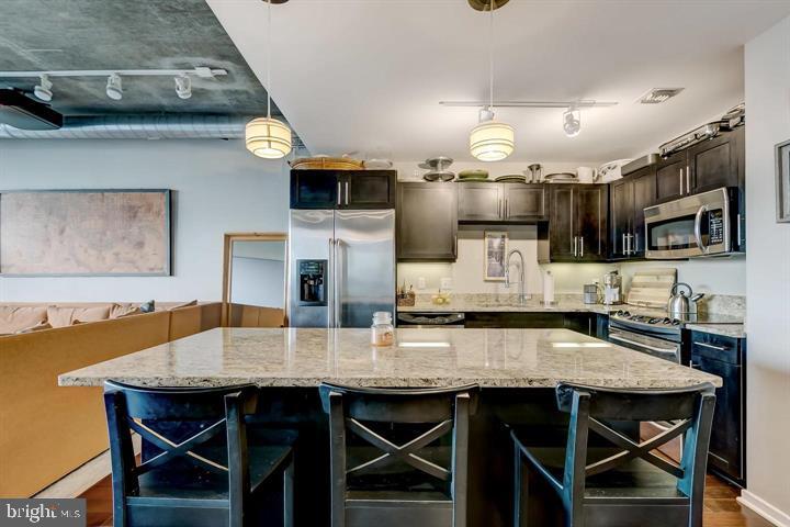 1200 Steuart Street, Unit 428 Baltimore, MD 21230 - Photo 18 of 53 a kitchen with kitchen island a dining table and chairs