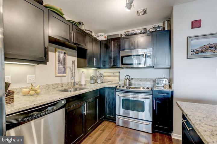 1200 Steuart Street, Unit 428 Baltimore, MD 21230 - Photo 20 of 53 a kitchen with stainless steel appliances granite countertop a sink a stove and cabinets