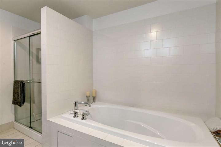 1200 Steuart Street, Unit 428 Baltimore, MD 21230 - Photo 34 of 53 a white bath tub sitting next to a white sink and vanity