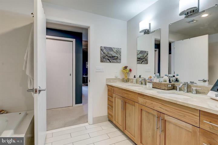 1200 Steuart Street, Unit 428 Baltimore, MD 21230 - Photo 36 of 53 a bathroom with a double vanity sink mirror and shower