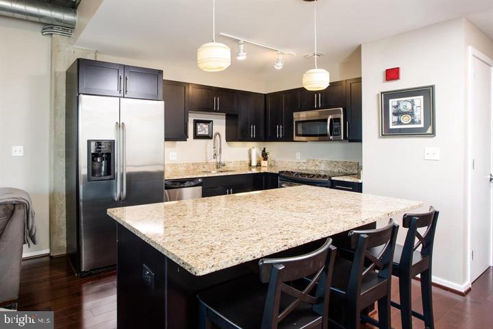 1200 Steuart Street, Unit 428 Baltimore, MD 21230 - Photo 5 of 53 a kitchen with a table and refrigerator