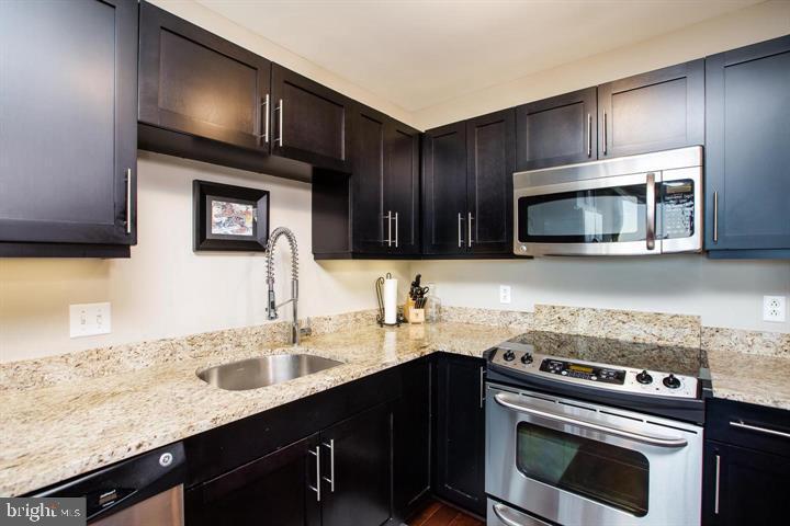 1200 Steuart Street, Unit 428 Baltimore, MD 21230 - Photo 10 of 53 a kitchen with granite countertop a stove microwave and sink
