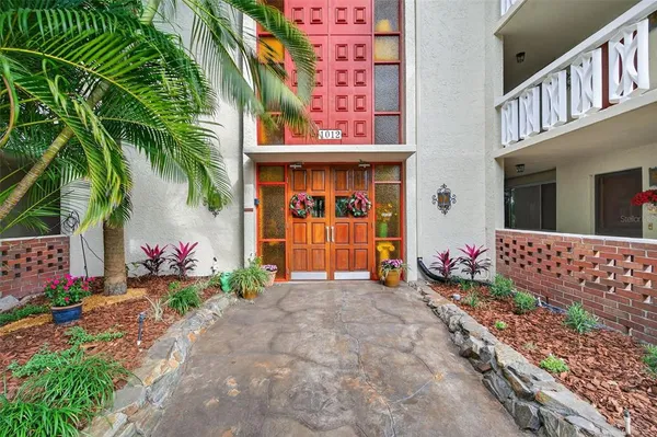 a view of a house with potted plants and a garage