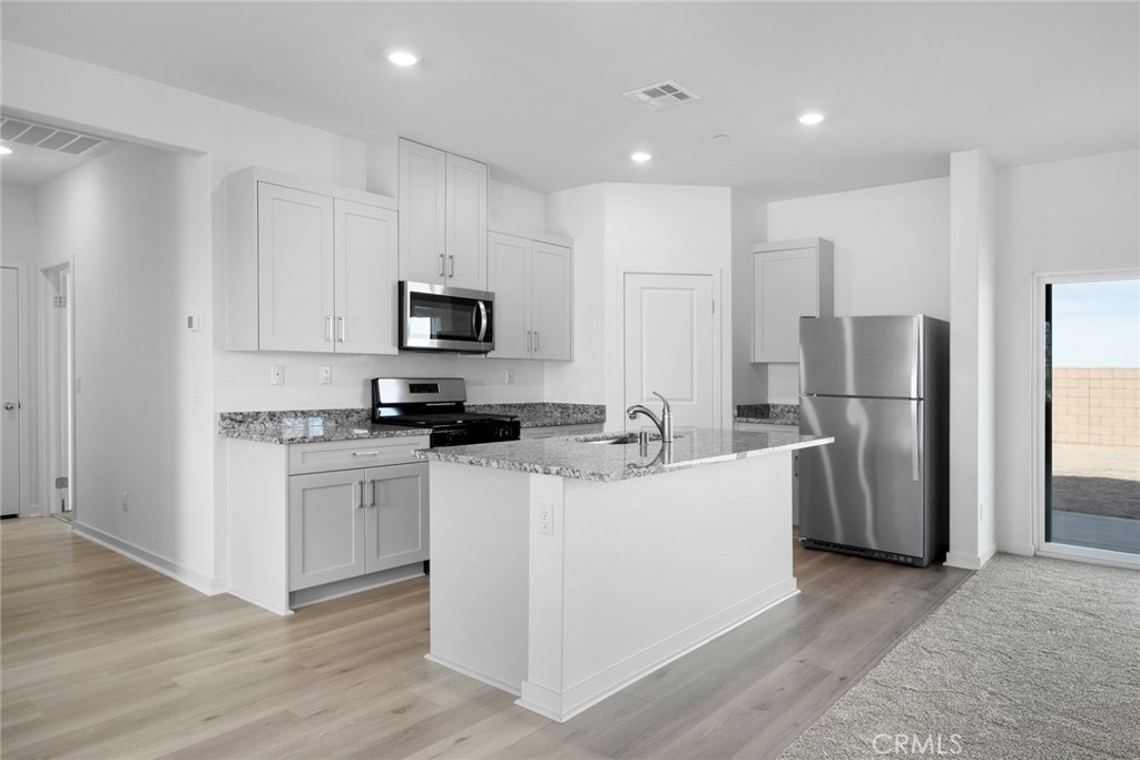 Undisclosed Address Victorville, CA 92392 - Photo 3 of 6 a kitchen with stainless steel appliances granite countertop a refrigerator stove a sink and a microwave