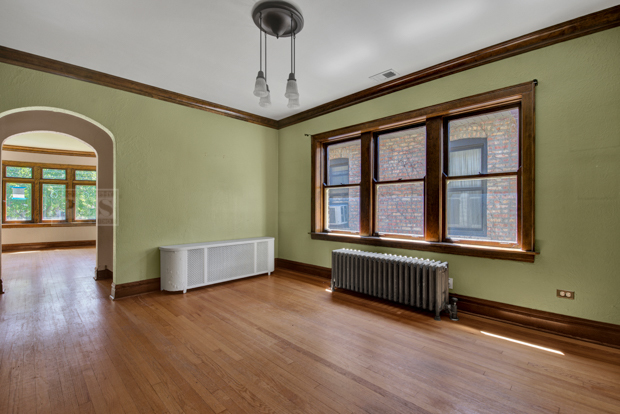 6727 Riverside Drive Berwyn, IL 60402 - Photo 7 of 30 a view of an empty room with a window and wooden floor