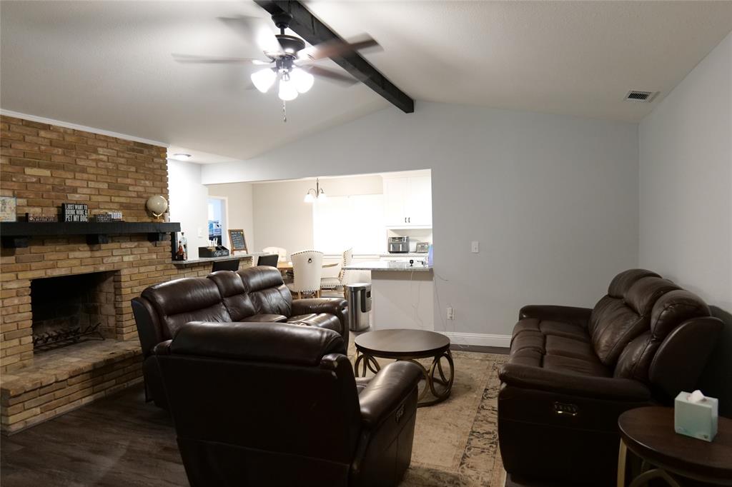 7137 Hunnicut Road Dallas, TX 75227 - Photo 9 of 16 Vaulted ceiling with exposed beam, brick fireplace with mantel, wood-finish flooring, and recessed lighting