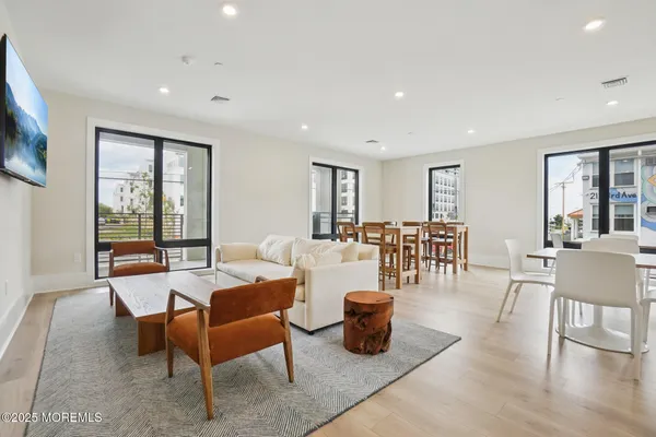 a living room with furniture a wooden floor and next to a window