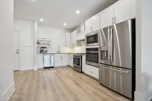 a kitchen with stainless steel appliances a refrigerator sink and microwave