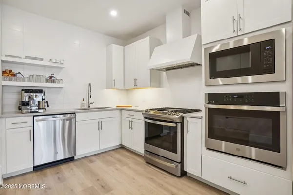 a kitchen with stainless steel appliances a stove microwave and sink