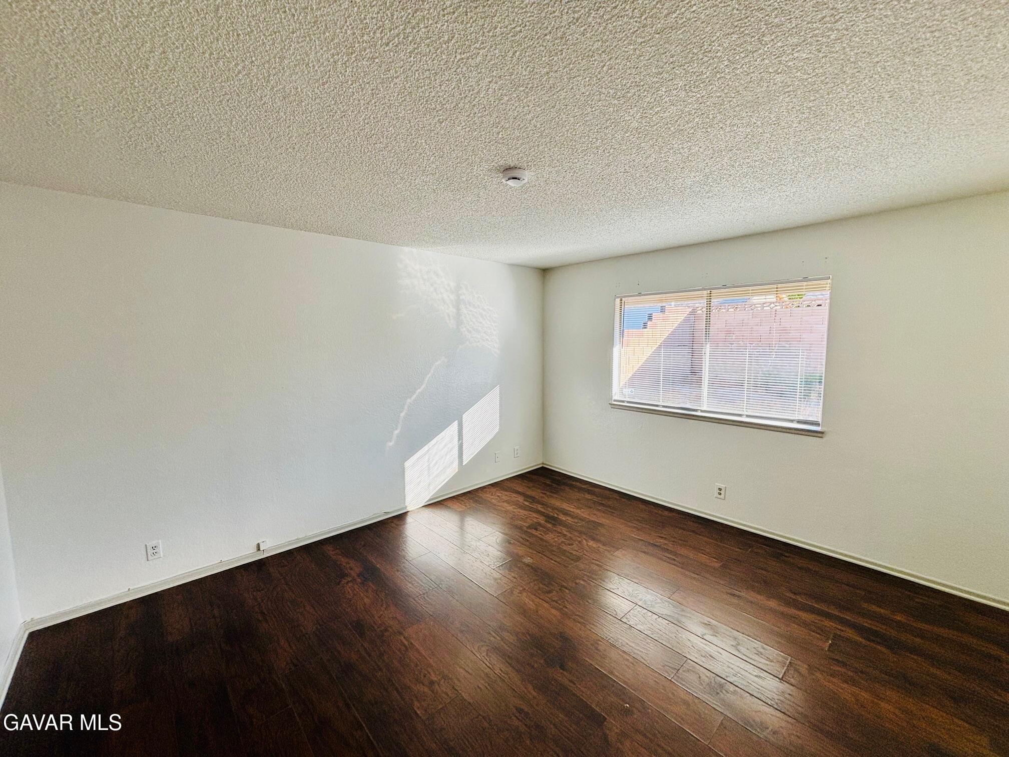2308 Edam Street Lancaster, CA 93536 - Photo 11 of 16 an empty room with wooden floor and windows
