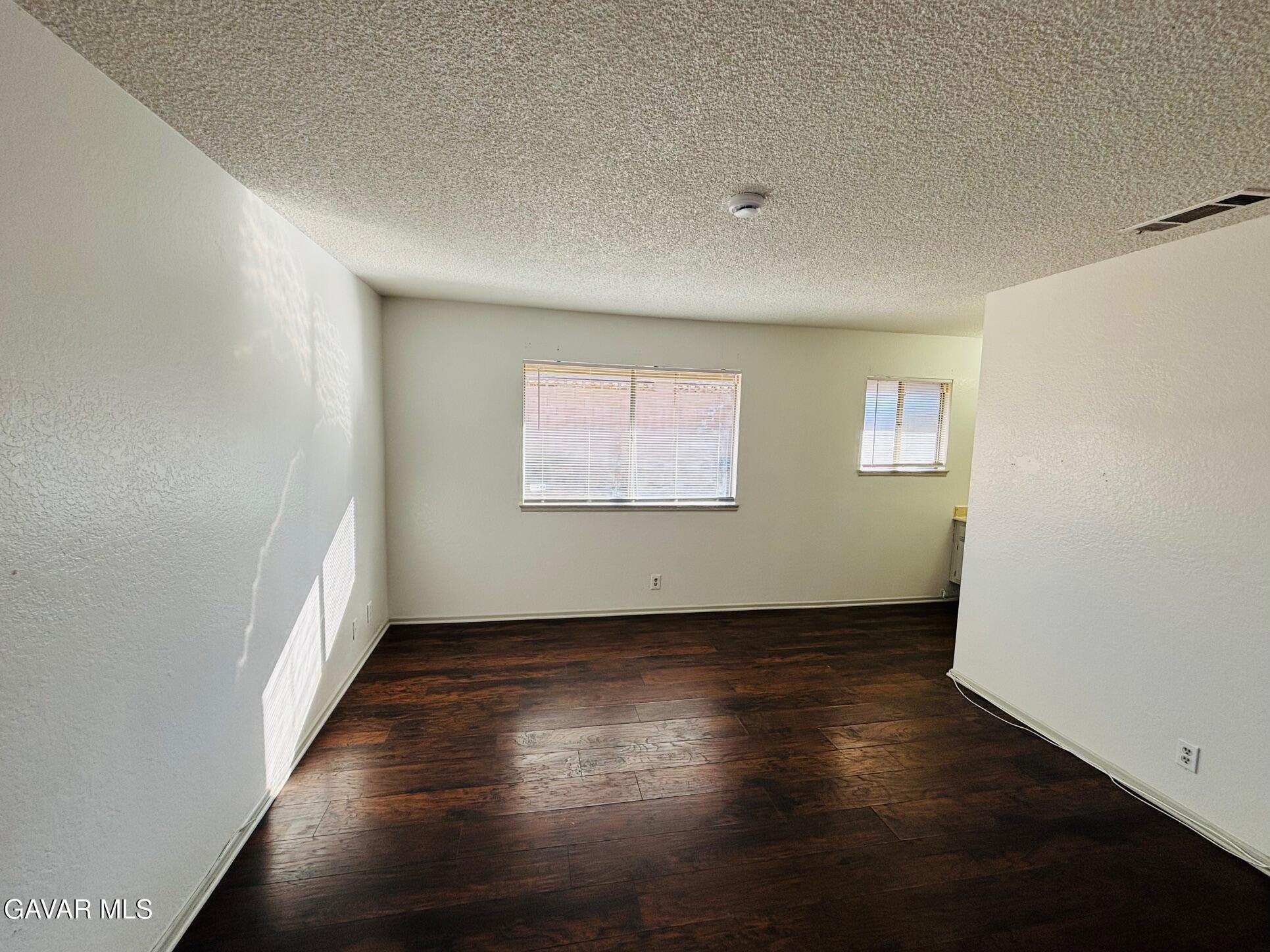 2308 Edam Street Lancaster, CA 93536 - Photo 7 of 16 an empty room with wooden floor and windows
