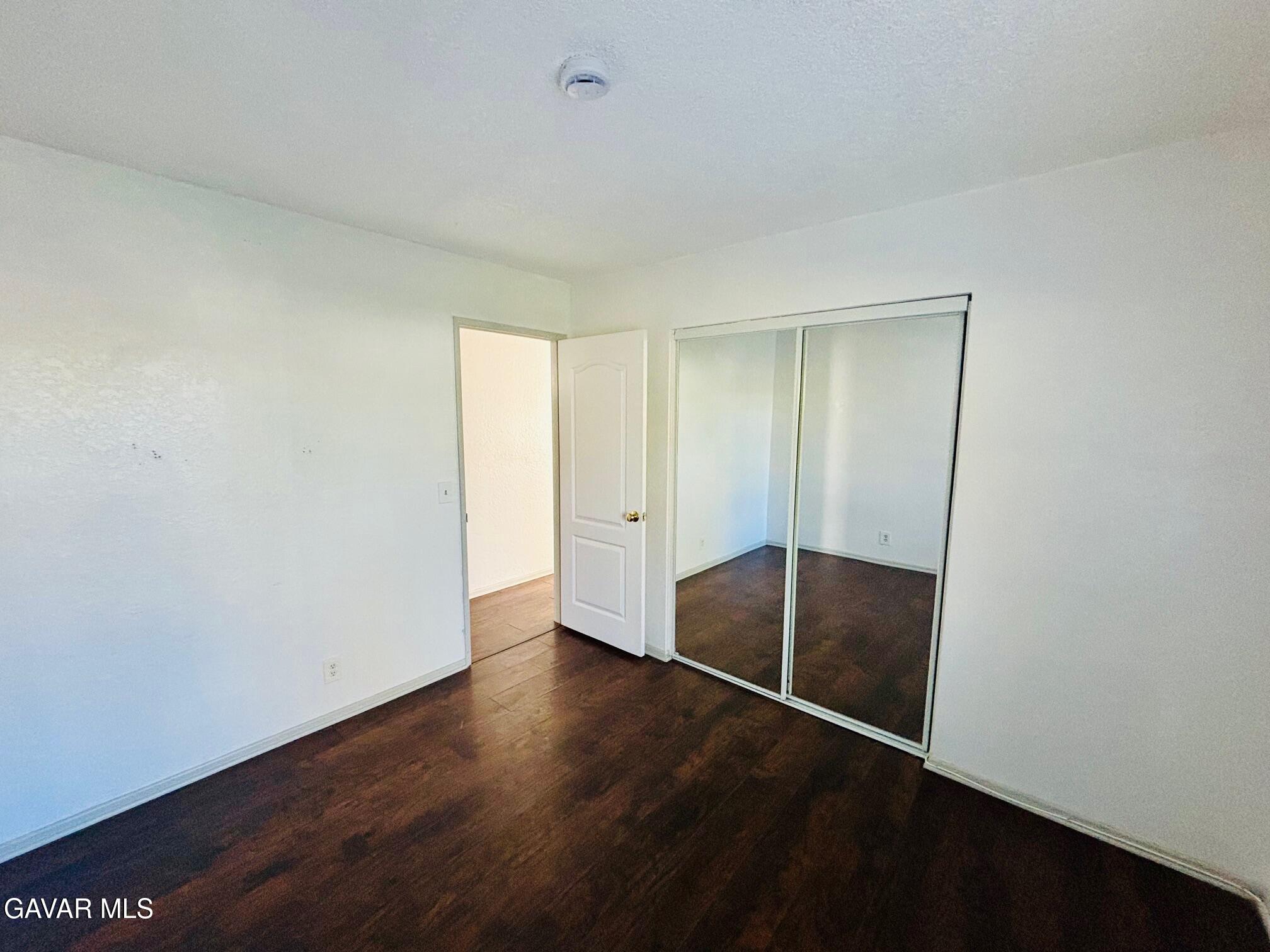 2308 Edam Street Lancaster, CA 93536 - Photo 10 of 16 an empty room with wooden floor and door