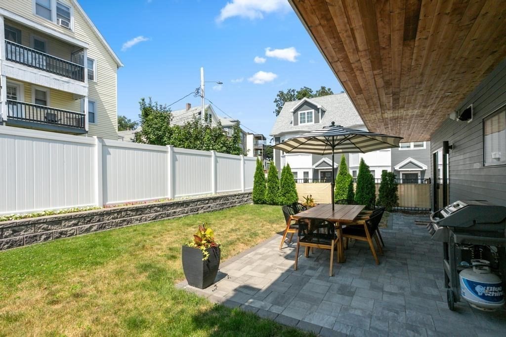 4 Payne Street, Unit 2 Boston, MA 02122 - Photo 21 of 28 a view of a patio with table and chairs potted plants with wooden fence
