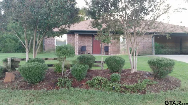 a view of a house with a yard and tree s