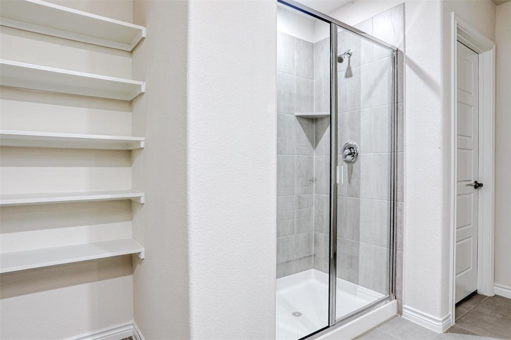 9813 Daisy Mae Aubrey, TX 76227 - Photo 20 of 28 a bathroom with a glass shower door