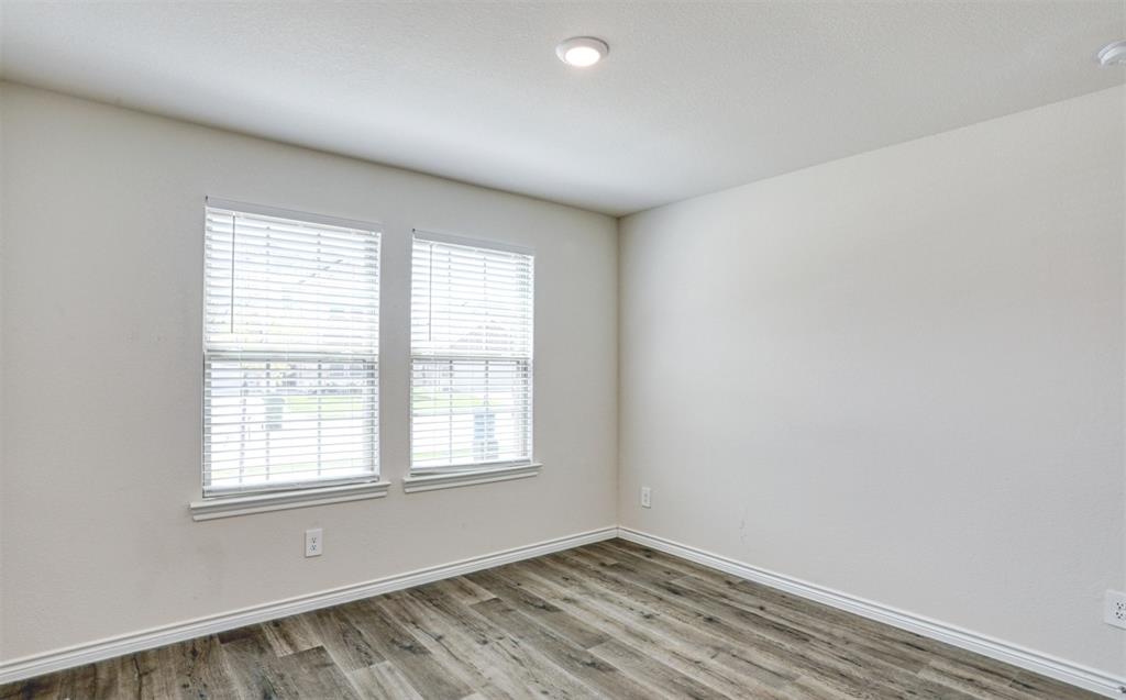 9813 Daisy Mae Aubrey, TX 76227 - Photo 23 of 28 an empty room with wooden floor and windows