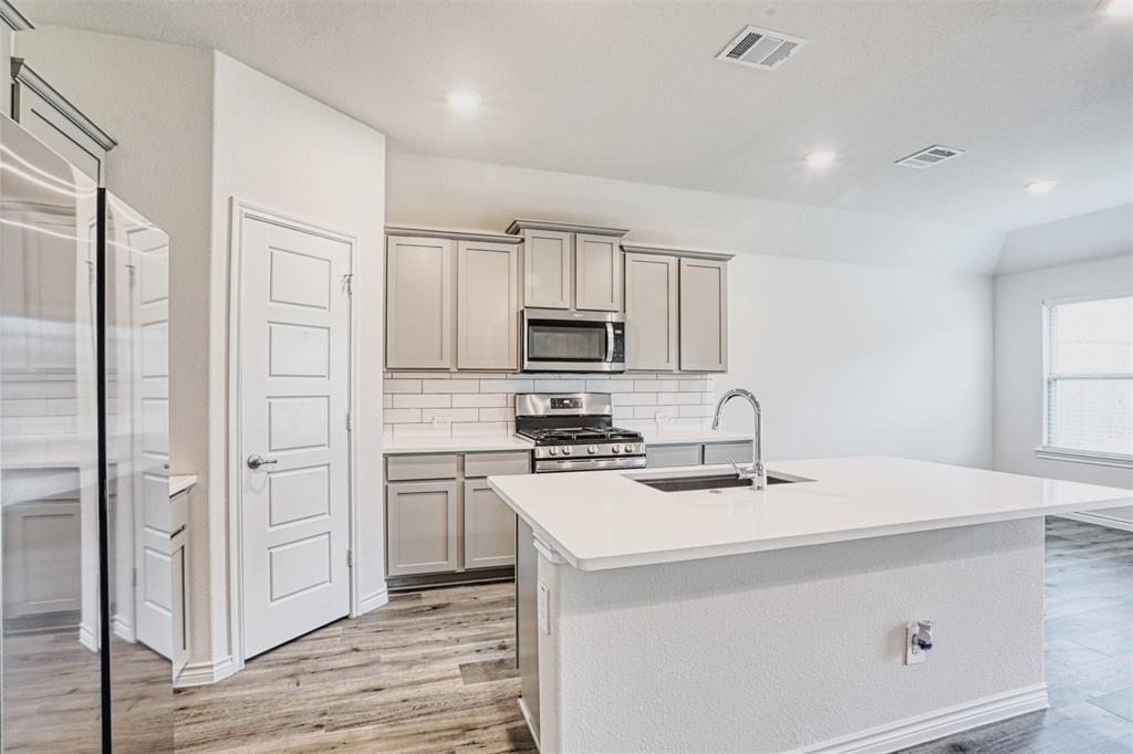 9813 Daisy Mae Aubrey, TX 76227 - Photo 4 of 28 a kitchen with a sink a stove and refrigerator