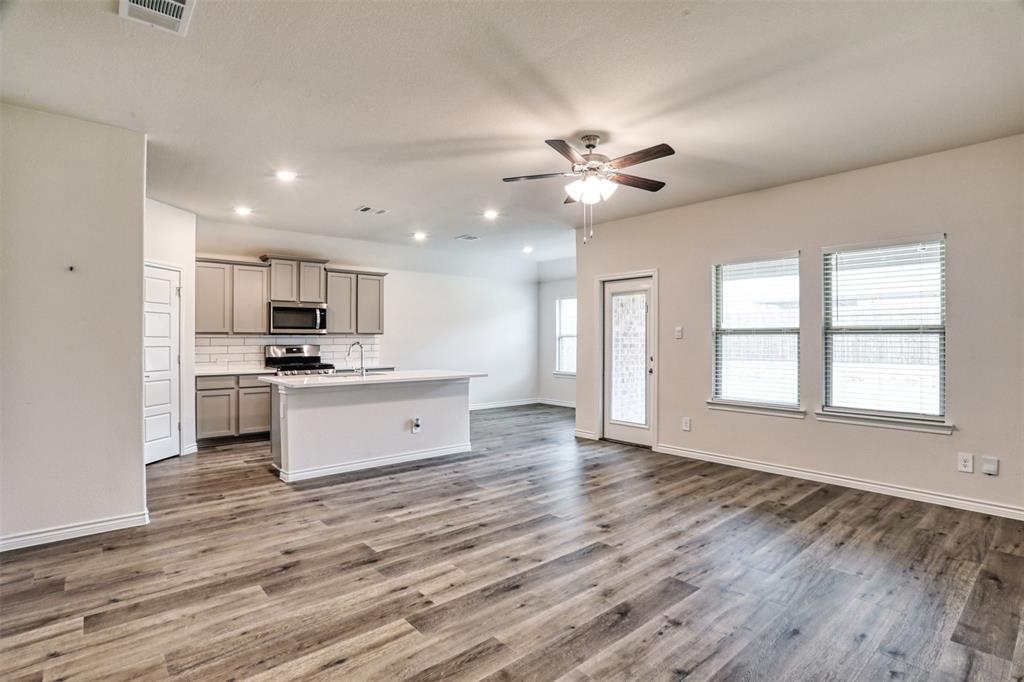 9813 Daisy Mae Aubrey, TX 76227 - Photo 5 of 28 a view of kitchen with granite countertop stove top oven and cabinets
